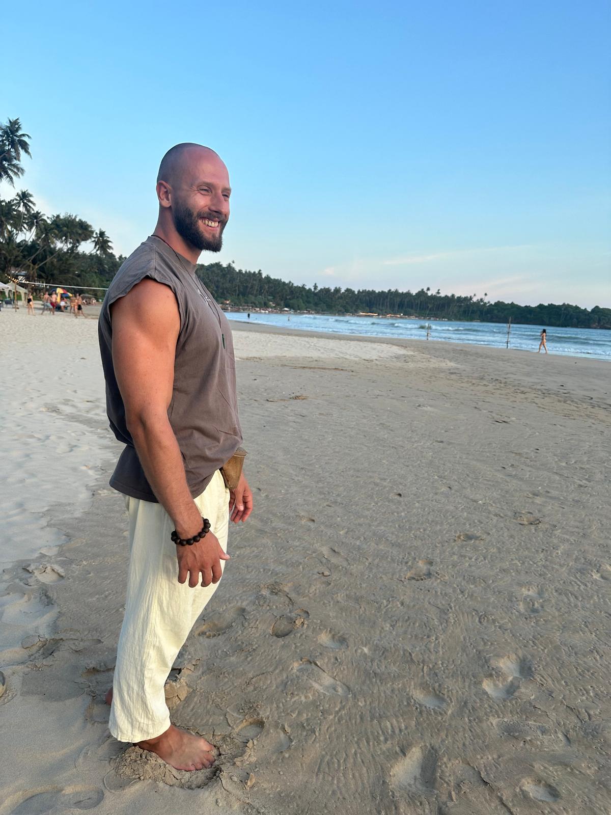 Person meditating on the beach at sunset